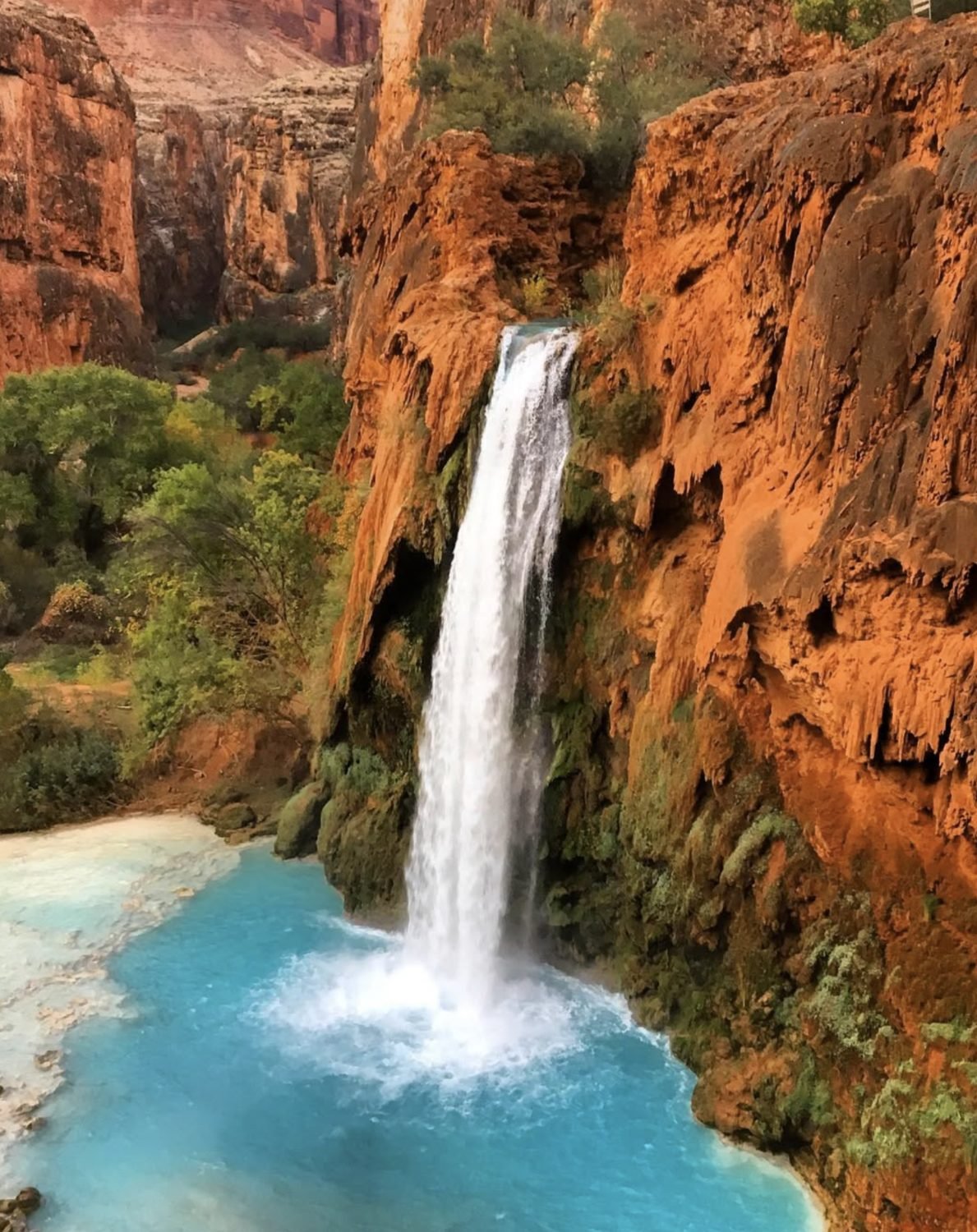 A desert waterfall falling into turquoise water