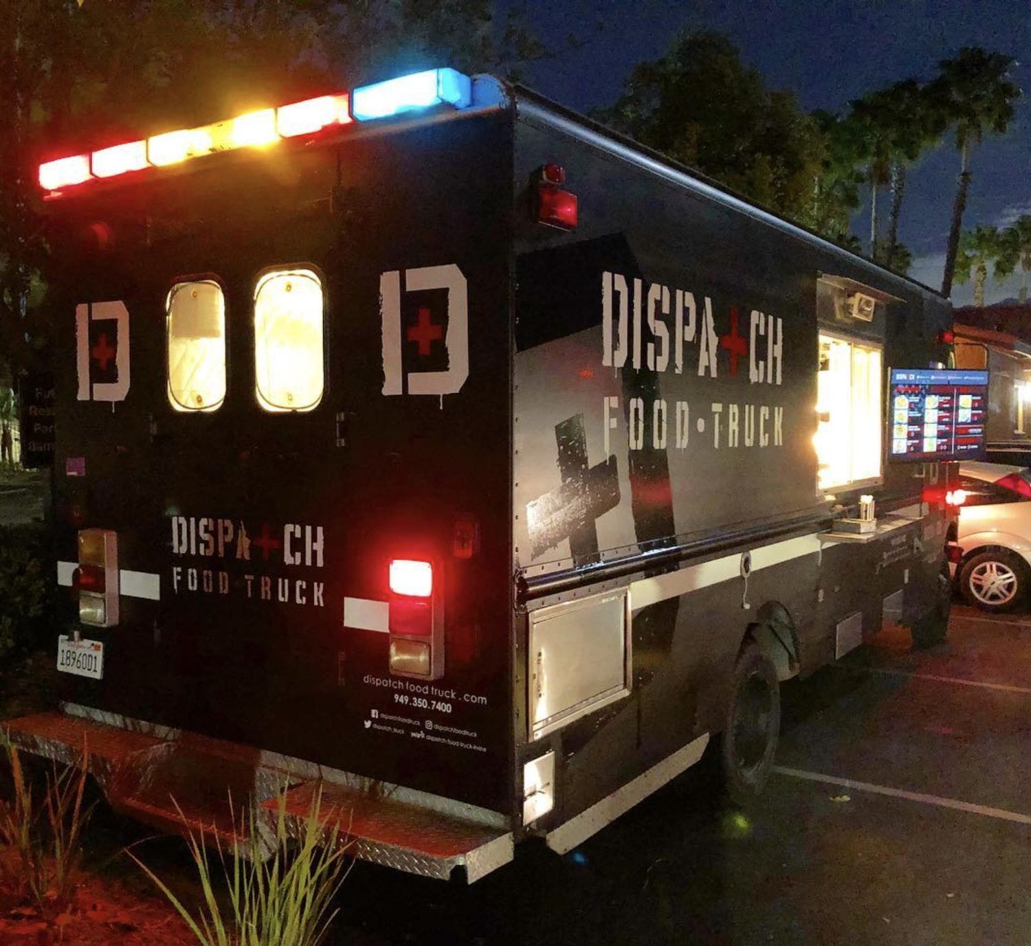 The food truck lit up at night with the service window open