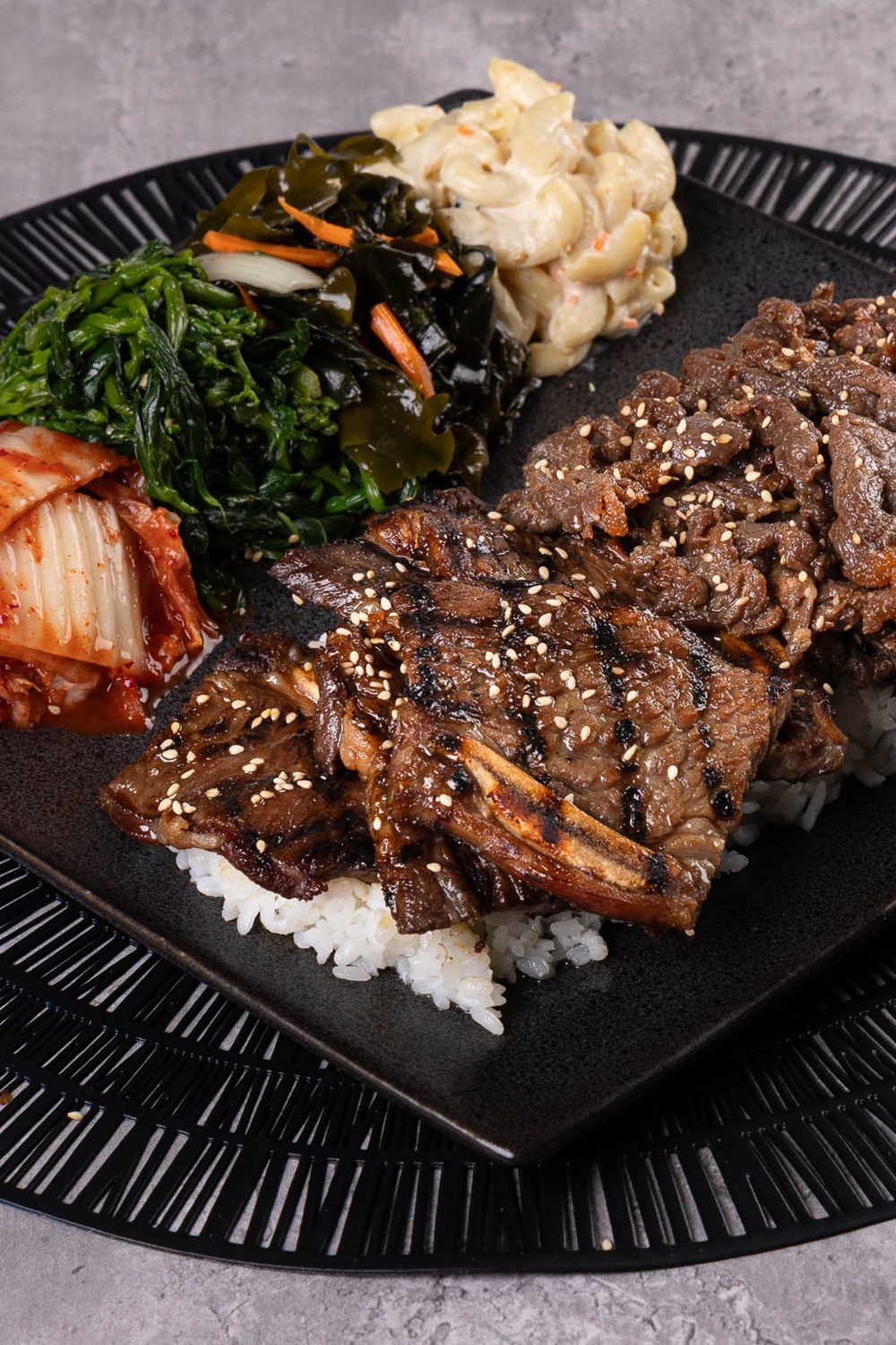 A Korean BBQ plate with short ribs, bulgogi, rice and banchan