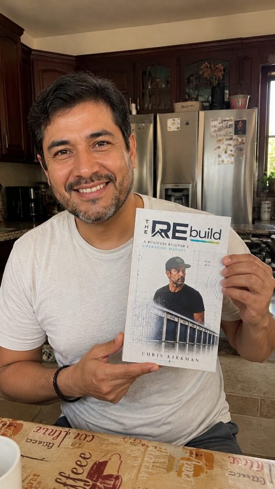 A restaurant owner holding The REbuild in his kitchen