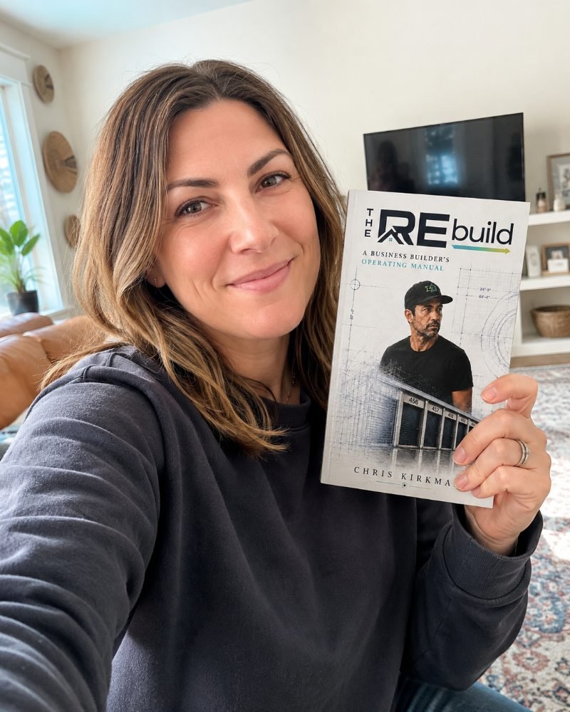 A reader holding The REbuild in her living room